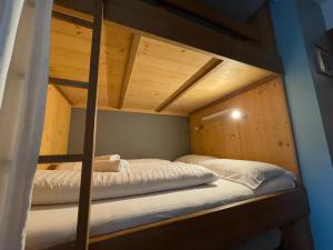 Ce lit se trouve dans un dortoir doté de 2 lits superposés et de murs en bois. dans l'établissement Apartment Blue Jeans, à Maria Alm