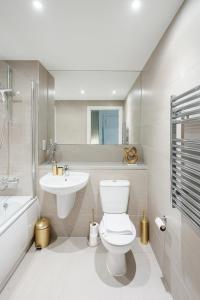 a white bathroom with a toilet and a sink at Beautiful & Contemporary Hackney Retreat in London