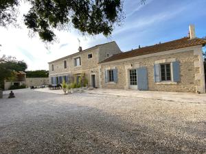 an exterior view of a stone house with a driveway at Gite Provençal du Mas Arnaud in Arles