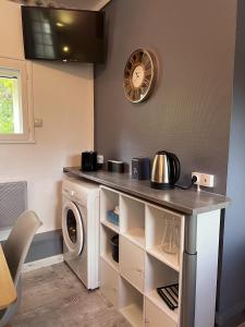 a laundry room with a washing machine and a counter at Bienvenue Chez Vous in Émancé