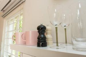 a shelf with wine glasses and mugs on it at Fig Tree in Pretoria