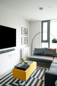 a living room with a couch and a tv at Beautiful & Contemporary Hackney Retreat in London