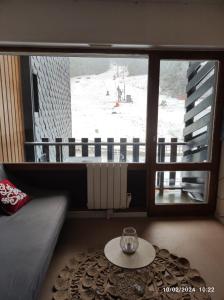 een woonkamer met een tafel en een groot raam bij Studio 4 places vue sur les pistes station de Puyvalador in Puyvalador