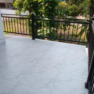 a balcony with a white tile floor and a black fence at Villa in Yakkala, Gampaha 