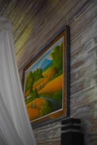 a painting hanging on a wall next to a curtain at Mesari Hut Lembongan in Nusa Lembongan