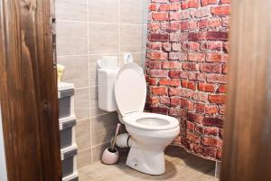 a bathroom with a toilet and a brick wall at Svilara in Novi Sad
