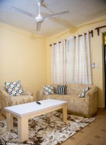 een woonkamer met een bank en een tafel bij Clarine Cozy Holiday Home in Mtwapa