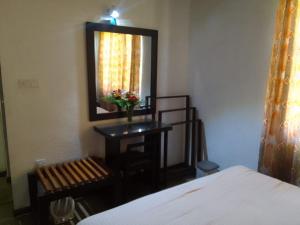 1 dormitorio con cama, espejo y silla en Nothern Residence, en Jaffna