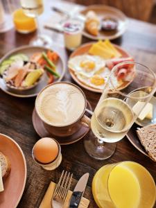 a wooden table with plates of breakfast foods and drinks at Boutique Hotel Marielle in Bad Münstereifel