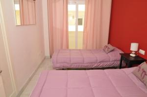 duas camas num quarto com lençóis cor-de-rosa em Estepona (in het hartje van het stadje) em Estepona