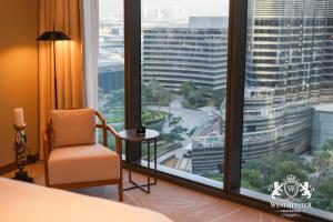 een hotelkamer met een stoel en een groot raam bij Westminster Opera Burj Khalifa in Dubai