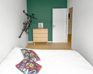 - une chambre avec un lit et un vélo suspendu au mur dans l'établissement Le cocon d’Oliver, à Compiègne