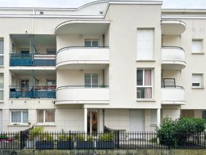 un immeuble d'appartements avec balcon et clôture dans l'établissement Le cocon d’Oliver, à Compiègne