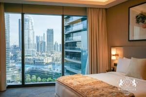 een slaapkamer met een groot raam met uitzicht op de stad bij Westminster Opera Burj Khalifa in Dubai