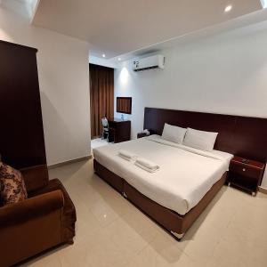 - une chambre avec un grand lit et un canapé dans l'établissement ALJAWHARA INN HOTEL, à Seeb