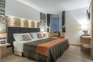 ein Schlafzimmer mit einem großen Bett in einem Zimmer in der Unterkunft Alpenresort Belvedere in Molveno