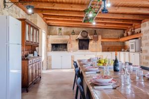 a large kitchen with a long table with chairs at Villa Giulia con Piscina Privata - Specchia in Specchia