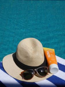 a straw hat and sunglasses next to a swimming pool at Hapu Tales - Private Holiday Villa in Haputale