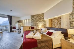 a bedroom with a bed with two bags on it at Alpenresort Belvedere in Molveno