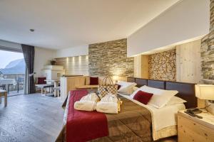 a bedroom with a bed with two bags on it at Alpenresort Belvedere Wellness & Beauty in Molveno