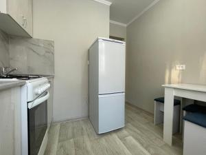 a kitchen with a white refrigerator in a room at 2-комнатная квартира в центре города, Интернациональная 94 in Petropavlovsk +5 photos