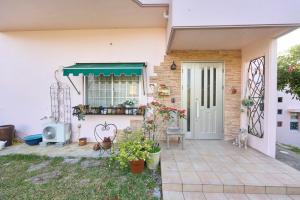 eine Veranda eines Hauses mit grüner Tür in der Unterkunft グリーンハウス in Nanjō