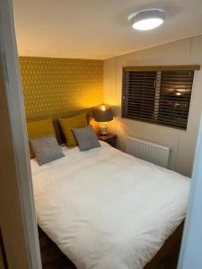 a bedroom with a large white bed with two pillows at 2 bedroom lodge - The Cherries (24) Caer beris holiday park in Builth Wells