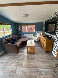 a living room with a couch and a table at 2 bedroom lodge - The Cherries (24) Caer beris holiday park in Builth Wells