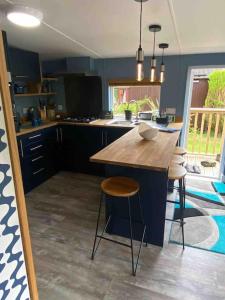 a kitchen with a island with a wooden counter top at 2 bedroom lodge - The Cherries (24) Caer beris holiday park in Builth Wells