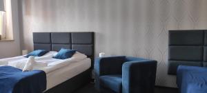 a bedroom with a bed and a blue chair at Harmonica Studio in Nowy Sącz