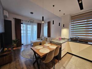 a kitchen and living room with a table and a couch at Deluxe Flat with garden_Tirana in Tirana