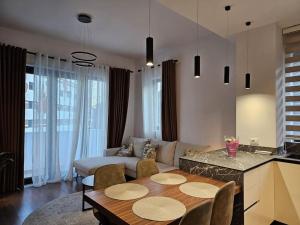 a living room with a table and a couch at Deluxe Flat with garden_Tirana in Tirana