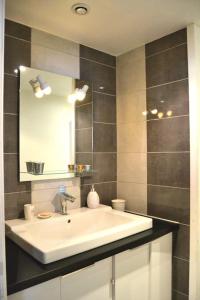 La salle de bains est pourvue d'un lavabo blanc et d'un miroir. dans l'établissement RESSOURCEZ VOUS AU SOLEIL, à Sérignan