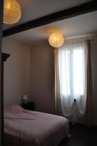 - une chambre avec un lit, une fenêtre et deux lumières dans l'établissement RESSOURCEZ VOUS AU SOLEIL, à Sérignan