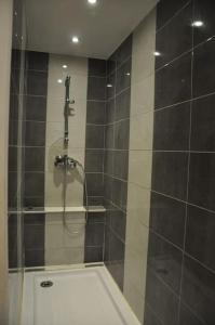La salle de bains est pourvue d'une douche avec une porte en verre. dans l'établissement RESSOURCEZ VOUS AU SOLEIL, à Sérignan