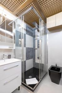 ein Badezimmer mit einer Glasdusche und einem schwarzen WC in der Unterkunft Maison Bilot in Rom