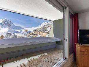 a room with a large window with a mountain view at Studio La Mongie, 1 pièce, 5 personnes - FR-1-404-351 in Bagnères-de-Bigorre