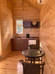 una mesa y sillas en una habitación pequeña con cocina en Lodge Güitimó en Ancud