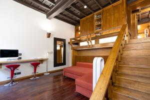 ein Wohnzimmer mit Holztreppe und roten Hockern in der Unterkunft Maison Bilot in Rom