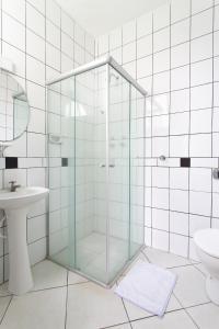 a glass shower in a bathroom with a sink at Hotel Dom Rafael Express in Santa Maria