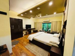 een slaapkamer met een groot bed en een televisie bij Royal Palms Luxury Service Apartment in Nagpur