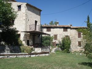 un grande edificio in pietra con balcone in un cortile di Chambres d'hotes - La Maison de Julie a Entrevaux