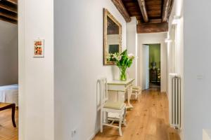 a room with a table with chairs and a vase of flowers at Agriturismo Il Leone della Torre in Contrada Ronchiel