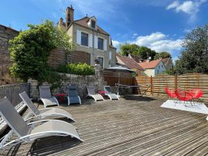 une terrasse avec des chaises, une table et une maison dans l'établissement 15 personnes Chez Delphine et Guillaume, à Montbard