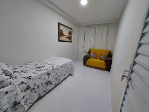 Residencial Atalaia Sul في أراكاجو: غرفة نوم فيها سرير واريكة