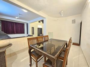 a dining room with a glass table and chairs at Seven Villa with Swimming pool in Panchgani