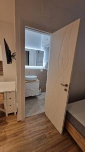 łazienka z drzwiami prowadzącymi do sypialni z umywalką w obiekcie La perla di Ro w mieście Savona