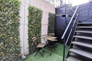 uma escada com duas cadeiras e um banco ao lado de uma parede em Cosy 1bed apartment with nice patio and fast WIFI F1 em Dublin