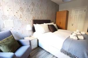 um quarto com 2 camas, uma cadeira azul e uma cama em Cosy 1bed apartment with nice patio and fast WIFI F1 em Dublin