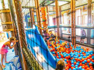 un gruppo di bambini che giocano in una struttura ricreativa con le palle di Family Hotel Alexander a Lido di Jesolo